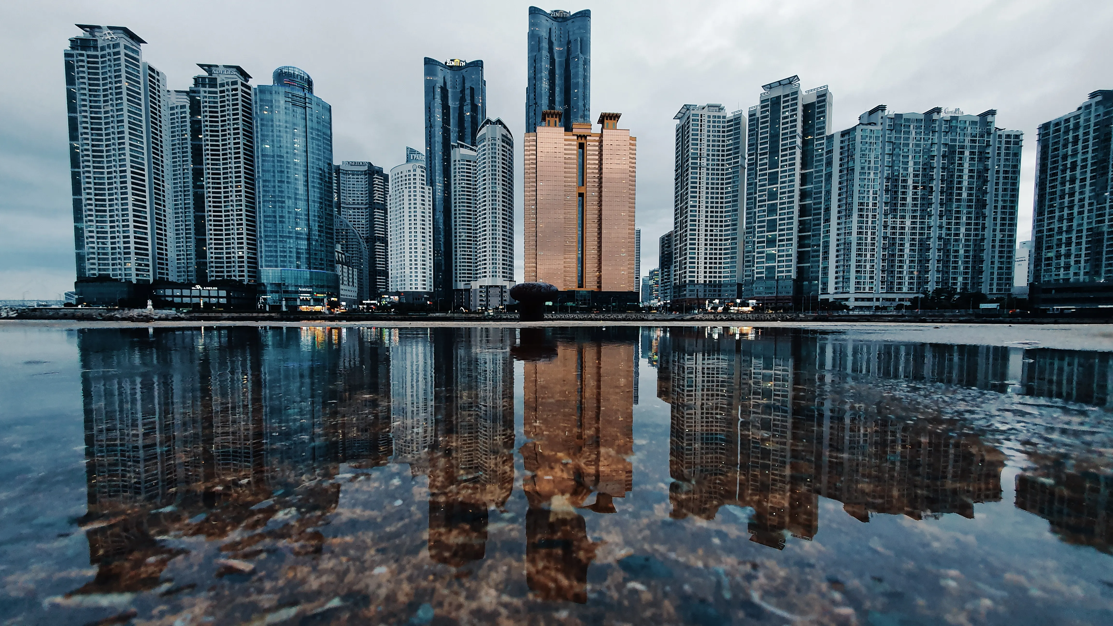 Busan waterfront towers reflected at blue hour