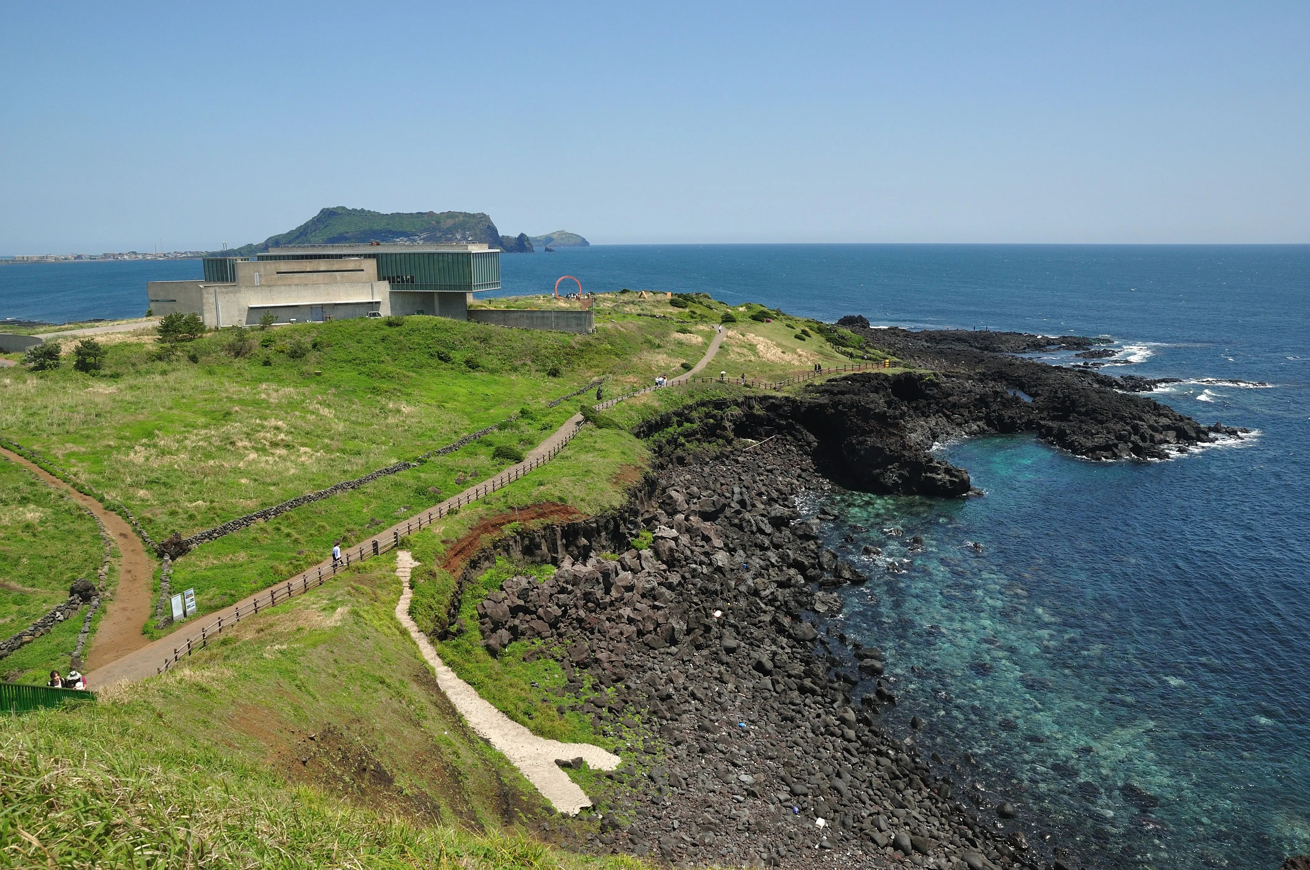 Jeju coastline with open sea and a distant island