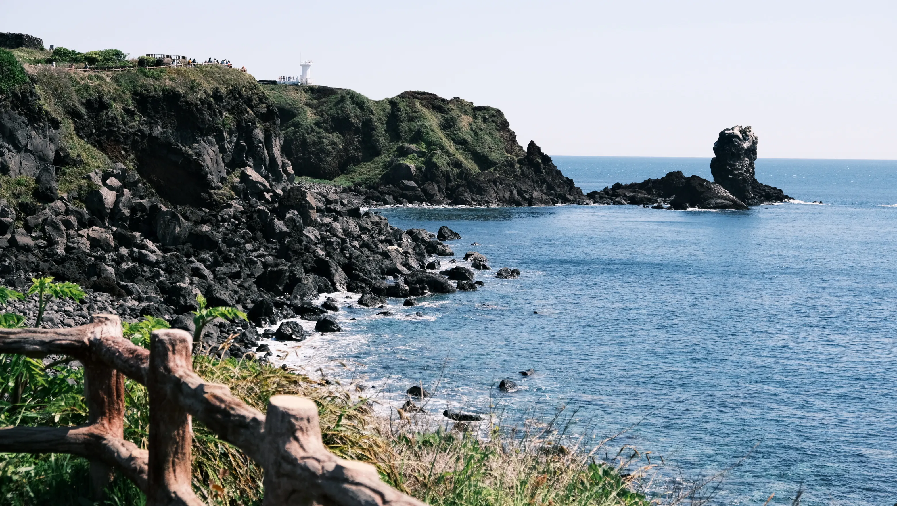 Basalt cliffs meeting the blue sea on Jeju